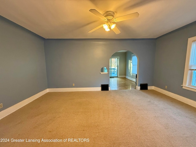 spare room with ceiling fan and light colored carpet