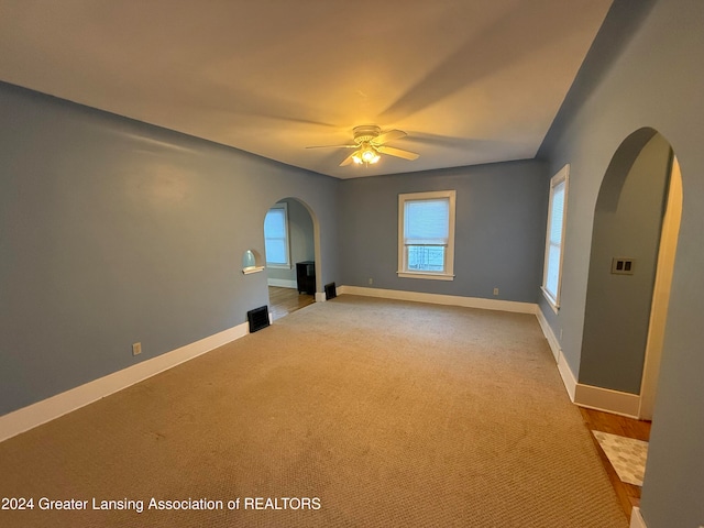 empty room featuring light colored carpet and ceiling fan