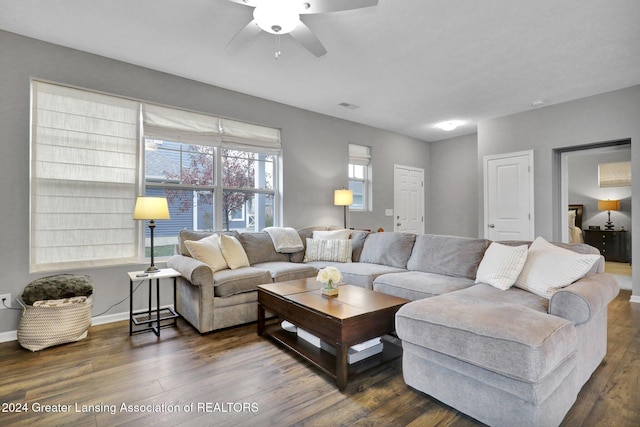 living room featuring visible vents, a ceiling fan, baseboards, and wood finished floors