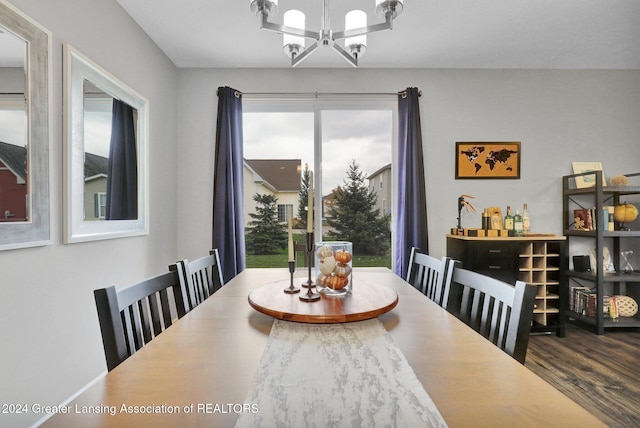 dining area with a healthy amount of sunlight, wood finished floors, and a notable chandelier