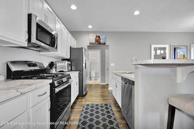 kitchen featuring a sink, dark wood finished floors, appliances with stainless steel finishes, and white cabinets