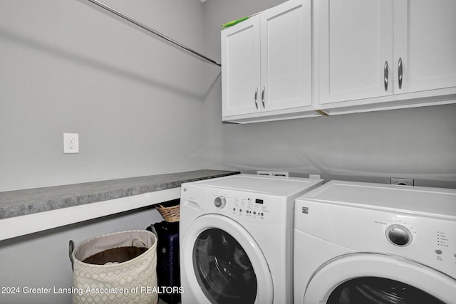 washroom with cabinet space and washer and dryer