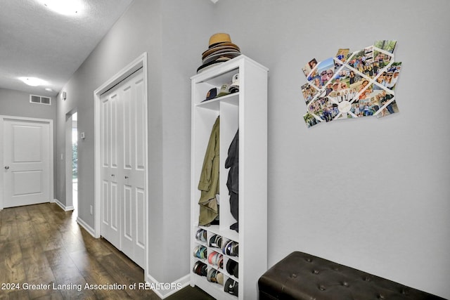 mudroom featuring visible vents, baseboards, and dark wood-style floors