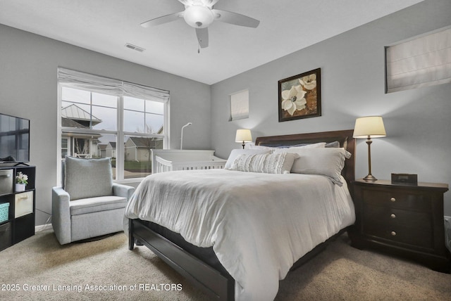 carpeted bedroom with a ceiling fan and visible vents