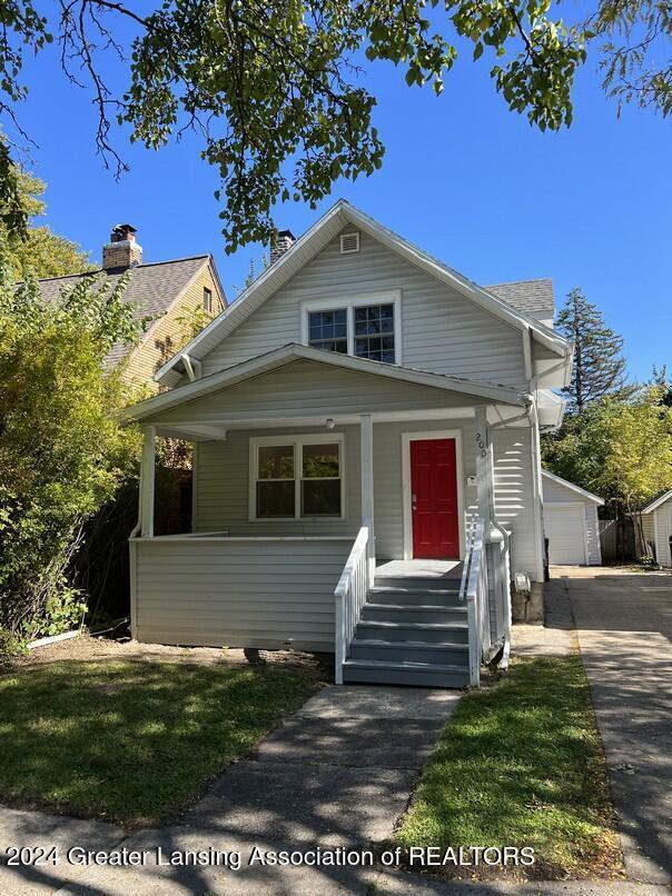 bungalow-style house with a garage and an outbuilding