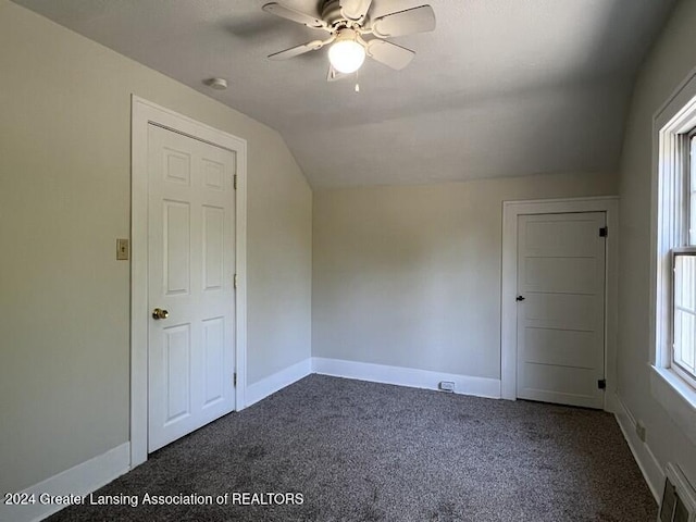 additional living space featuring ceiling fan, lofted ceiling, and dark colored carpet