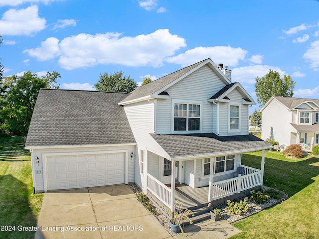 view of property featuring covered porch, a garage, and a front yard