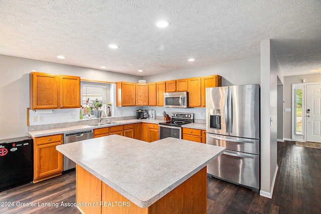 kitchen featuring a textured ceiling, dark wood-type flooring, sink, black appliances, and a kitchen island