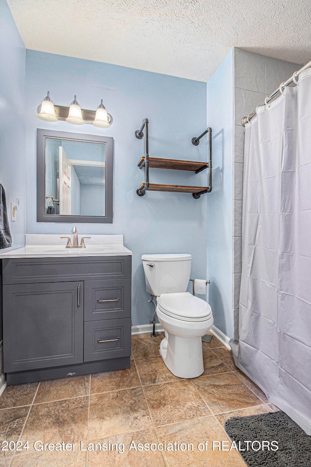 bathroom featuring a shower with curtain, tile patterned flooring, a textured ceiling, toilet, and vanity