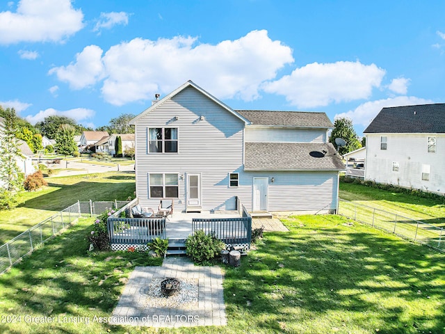 back of property featuring a lawn and a deck