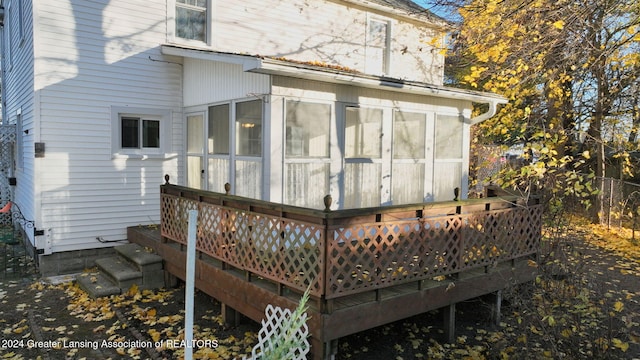 back of property featuring a deck and a sunroom