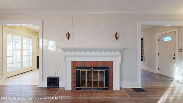 room details with crown molding, hardwood / wood-style floors, and a brick fireplace