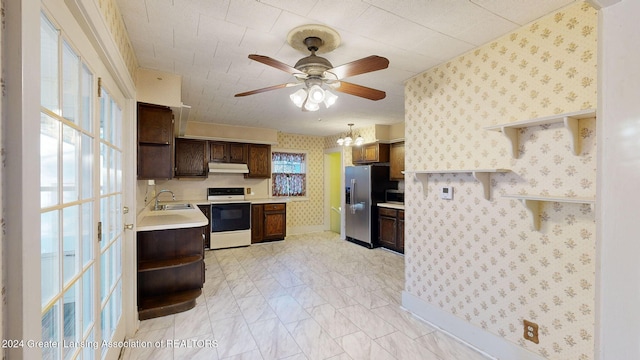 kitchen with dark brown cabinets, ceiling fan with notable chandelier, stainless steel appliances, sink, and pendant lighting