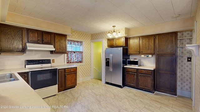 kitchen featuring sink, hanging light fixtures, appliances with stainless steel finishes, and an inviting chandelier