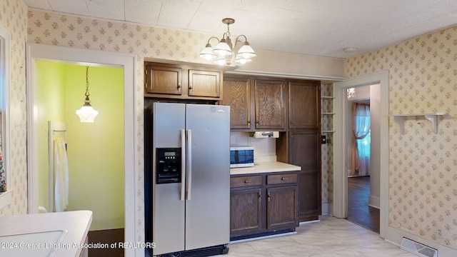 kitchen featuring an inviting chandelier, hanging light fixtures, and appliances with stainless steel finishes