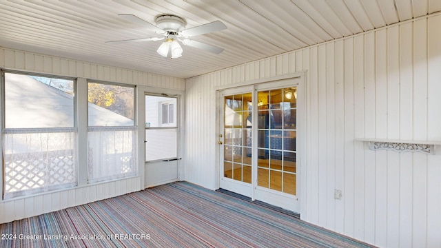 unfurnished sunroom featuring ceiling fan