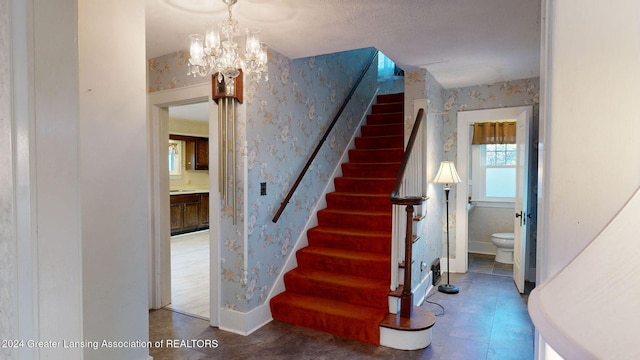 staircase featuring a chandelier