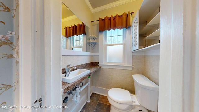 bathroom with sink, ornamental molding, tile walls, and toilet