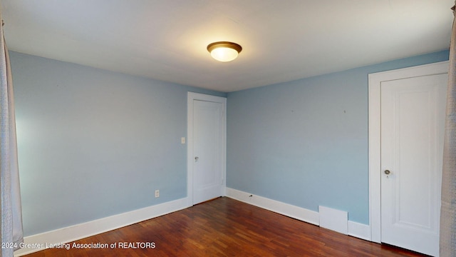 spare room with dark hardwood / wood-style flooring