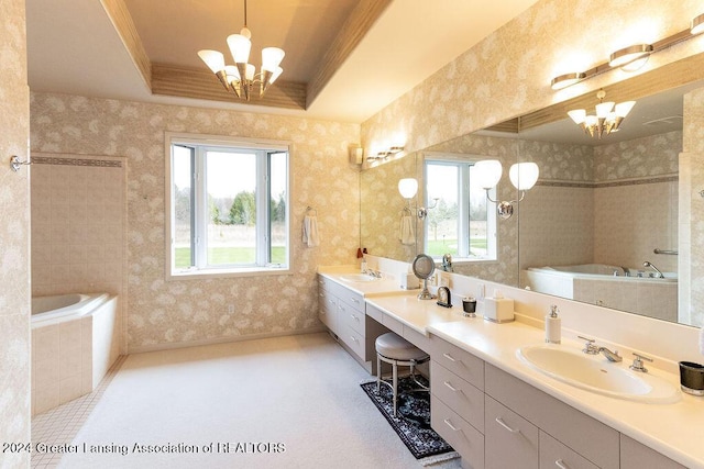 bathroom featuring a relaxing tiled tub, a raised ceiling, vanity, and an inviting chandelier