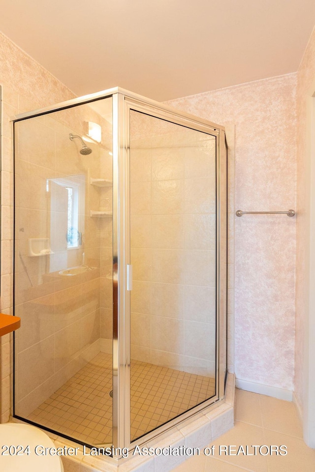 bathroom with tile patterned flooring and a shower with door