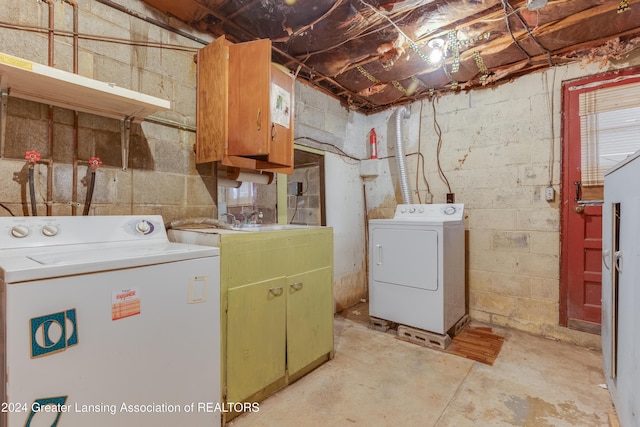 washroom featuring separate washer and dryer, sink, and cabinets