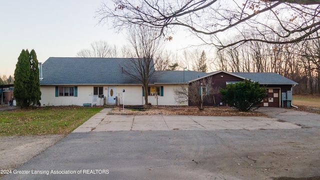 ranch-style home with a garage and a lawn