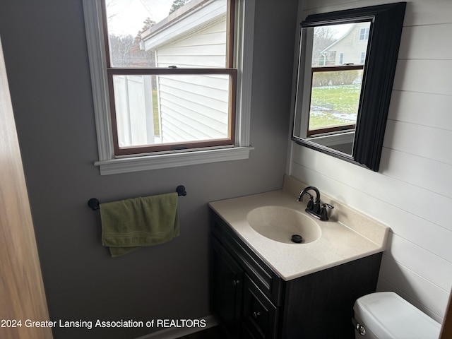 bathroom with vanity, tile walls, and toilet