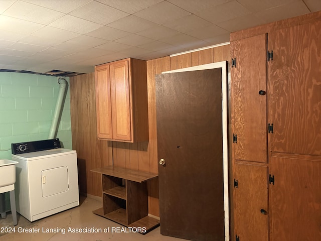 laundry room featuring cabinets, washer / dryer, and wood walls