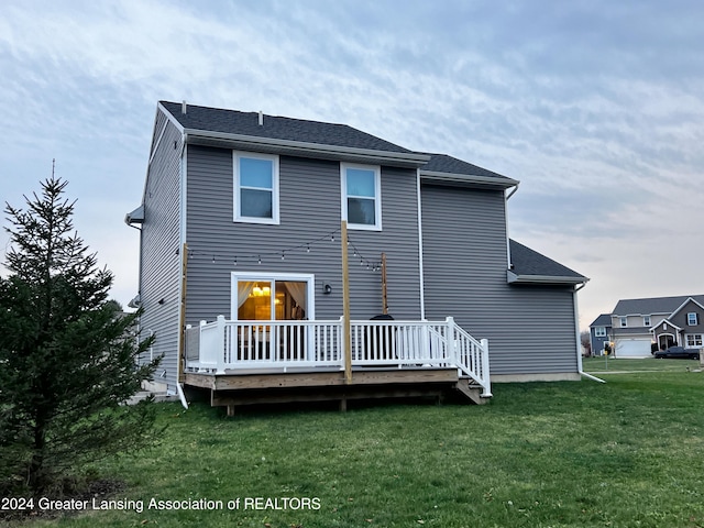 rear view of property featuring a deck and a yard