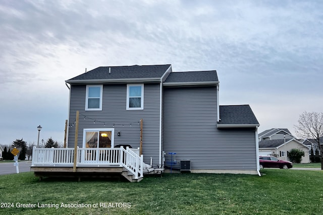 back of house with a lawn and a deck