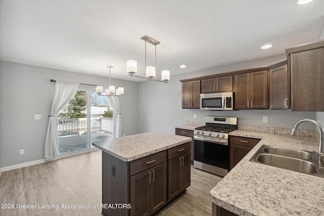 kitchen with a center island, light hardwood / wood-style floors, sink, and appliances with stainless steel finishes