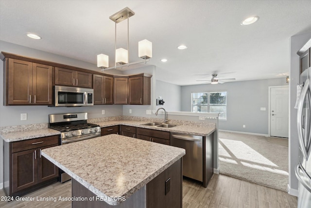 kitchen featuring sink, ceiling fan, decorative light fixtures, light hardwood / wood-style floors, and stainless steel appliances