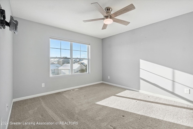 spare room featuring ceiling fan and carpet floors