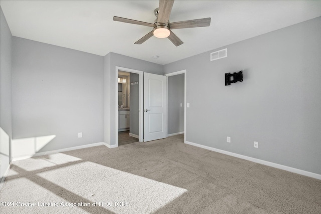 unfurnished bedroom with ceiling fan, carpet floors, and connected bathroom