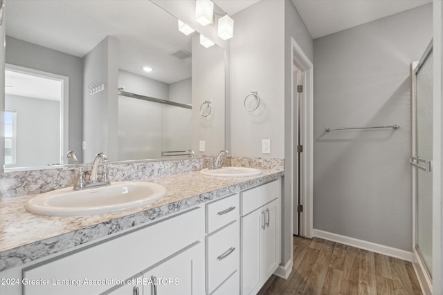 bathroom featuring hardwood / wood-style flooring, vanity, and a shower with shower door