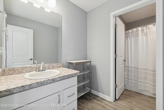 bathroom with a shower with curtain, vanity, and wood-type flooring