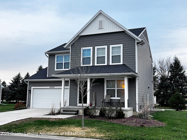 traditional-style home featuring concrete driveway, roof with shingles, an attached garage, and a front yard