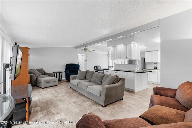 living room featuring ceiling fan, light hardwood / wood-style floors, a textured ceiling, and lofted ceiling with beams