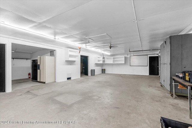 garage with white refrigerator with ice dispenser and ceiling fan