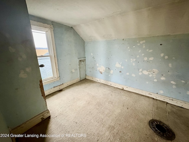 bonus room with lofted ceiling and light carpet