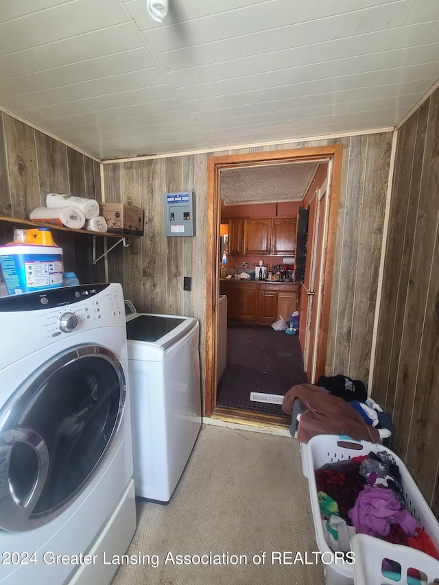 laundry area with independent washer and dryer and wooden walls