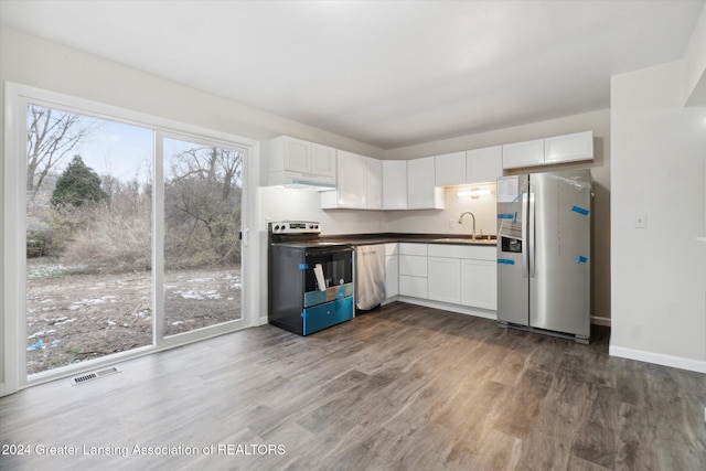 kitchen with stainless steel appliances, extractor fan, sink, white cabinets, and dark hardwood / wood-style floors