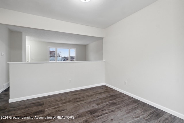 unfurnished room with dark hardwood / wood-style flooring