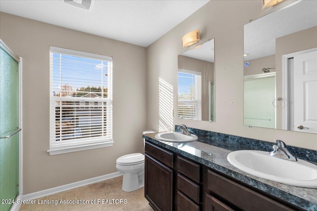 bathroom featuring tile patterned flooring, toilet, an enclosed shower, and a healthy amount of sunlight