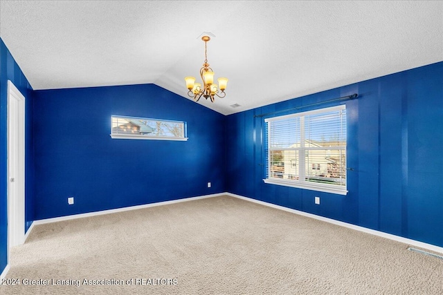 unfurnished room with carpet flooring, a notable chandelier, lofted ceiling, and a textured ceiling