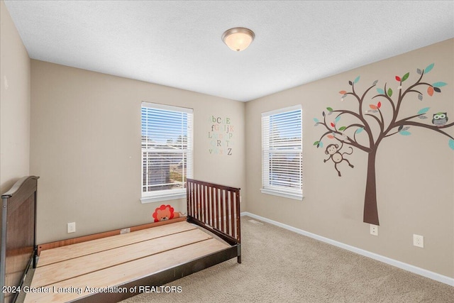 bedroom featuring a textured ceiling and carpet floors