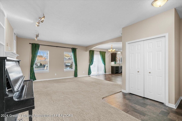 living room featuring dark hardwood / wood-style flooring, a textured ceiling, and a chandelier