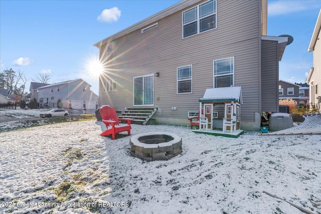 snow covered back of property featuring an outdoor fire pit