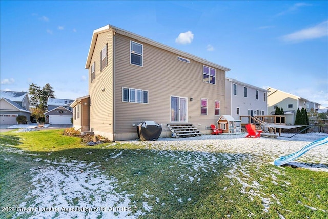 snow covered house with a playground and a lawn